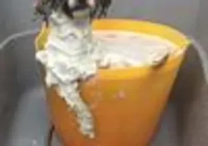 A picture of an orange cup with whipped cream on it.